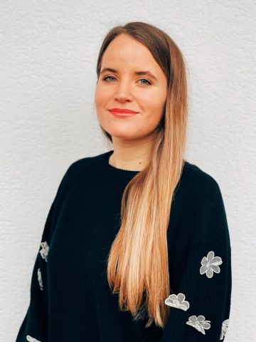 Fotka ženy u bílé zdi